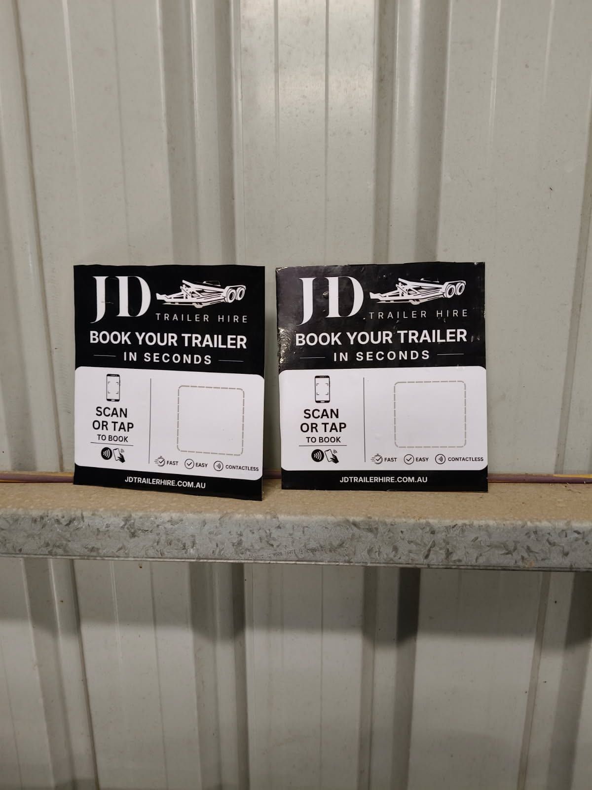 Custom JD Trailer Hire booking stickers ready to be applied to trailers