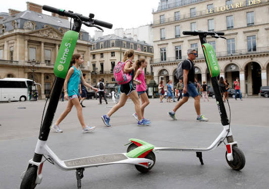 Lime e-scooters parked in a city plaza